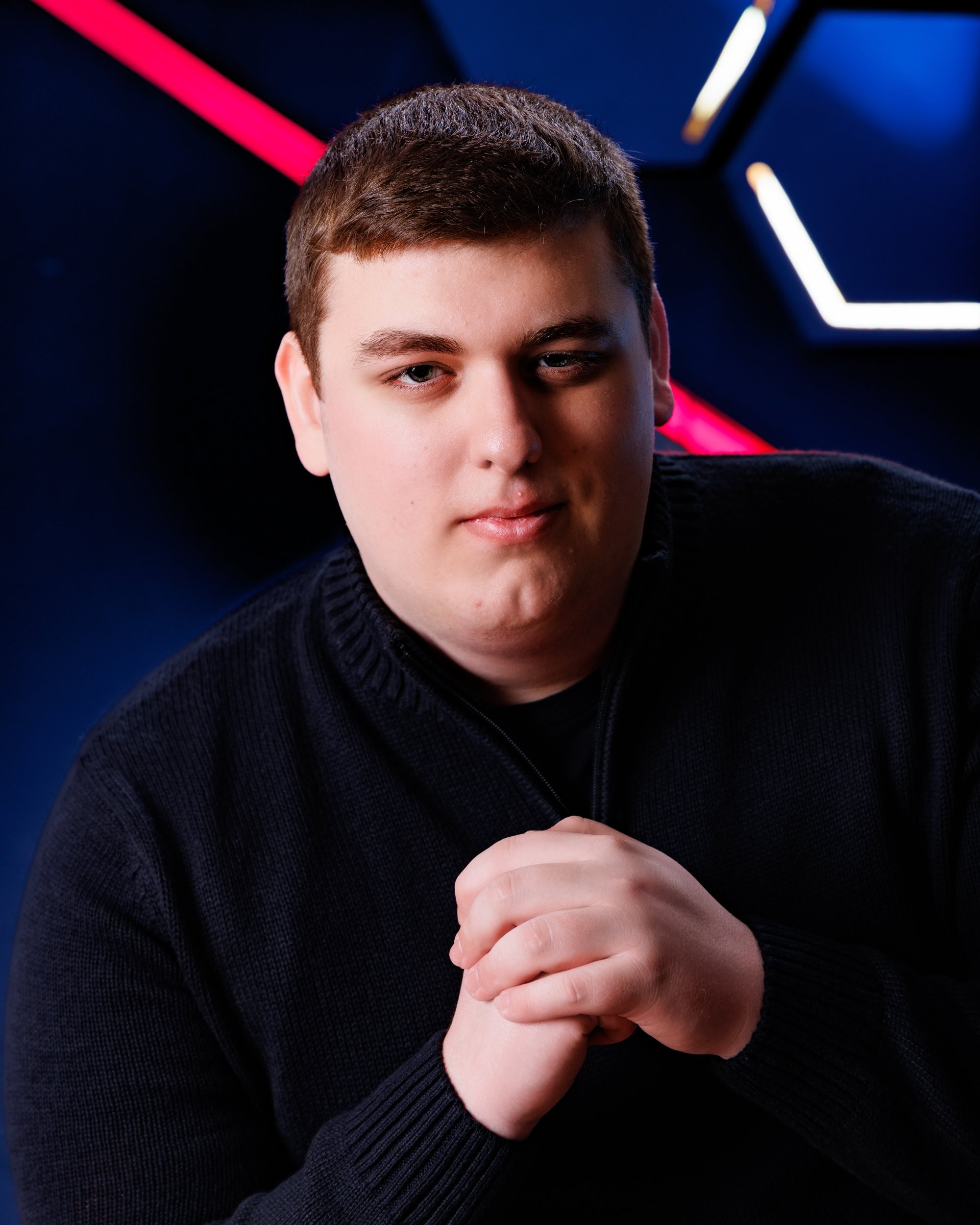 Matthew holding a game controller in a modern neon-lit studio environment
