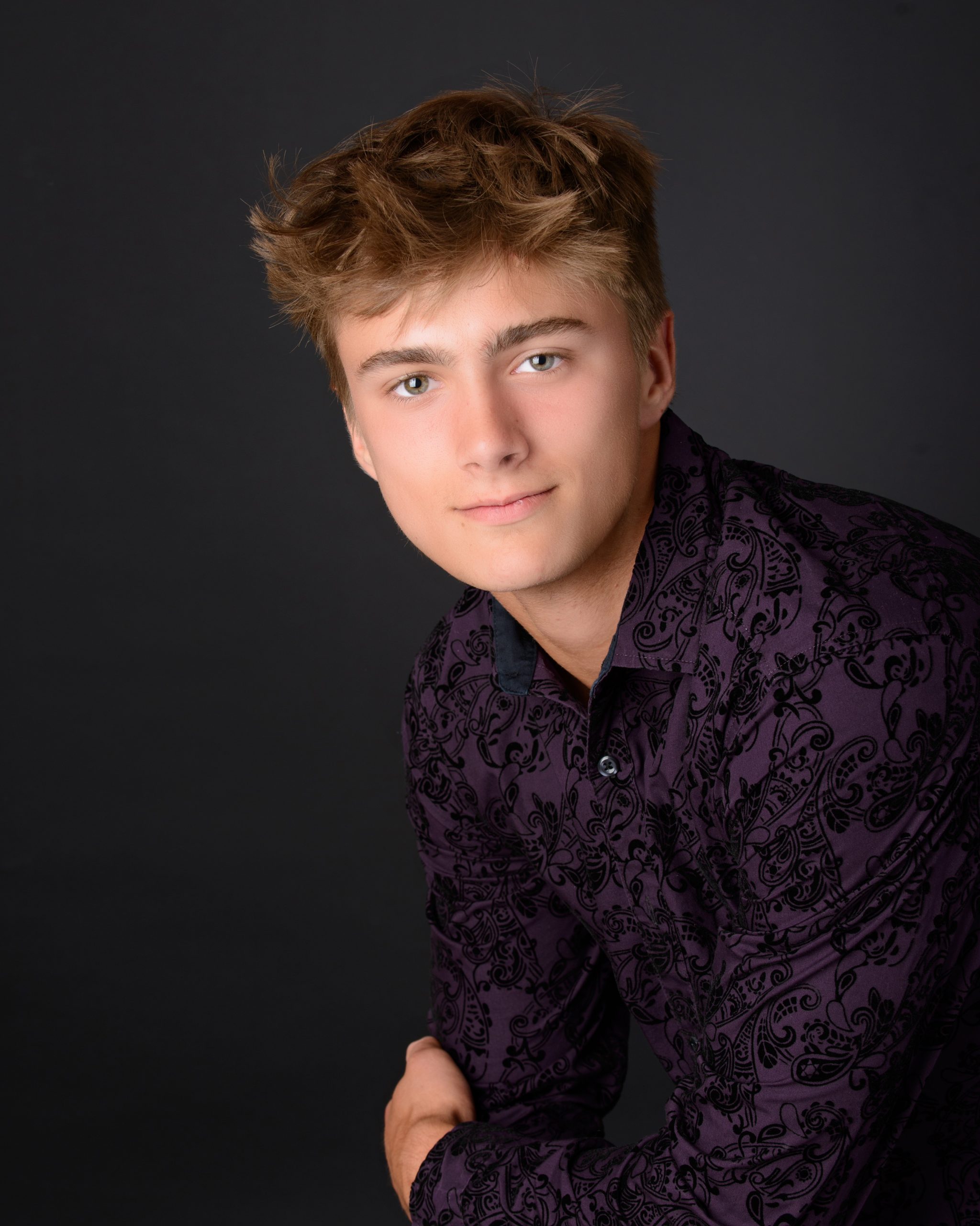 Casual Trenton senior session portrait showing a young man in layered clothing with a graffiti wall backdrop