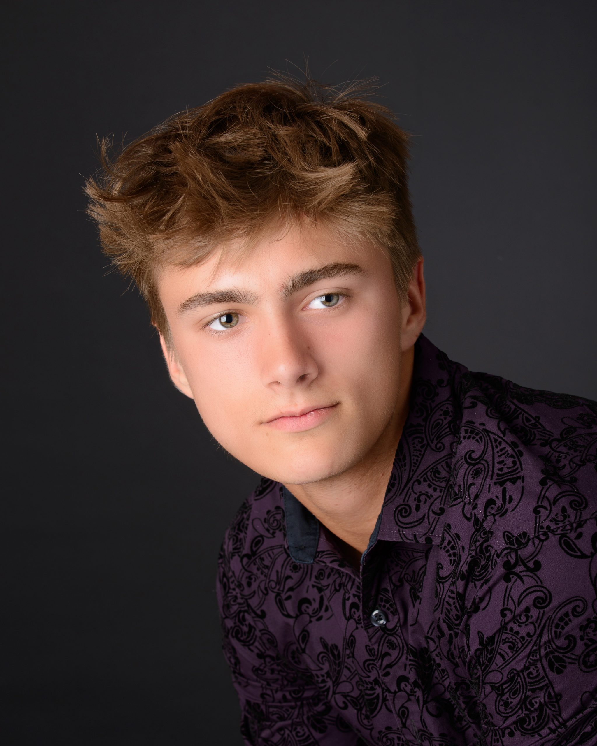 Casual Trenton senior session portrait showing a young man in layered clothing with a graffiti wall backdrop