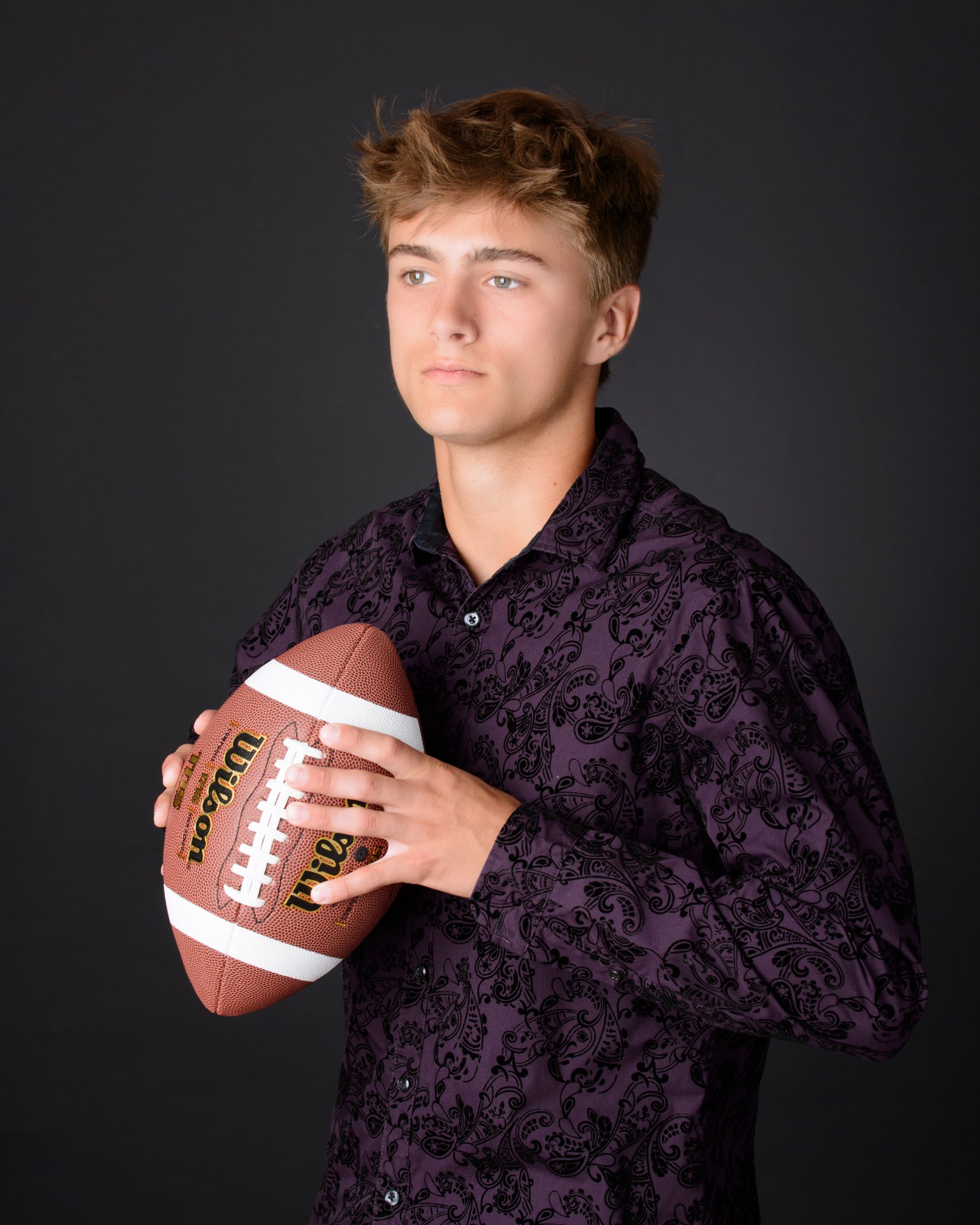 Casual Trenton senior session portrait showing a young man in layered clothing with a graffiti wall backdrop