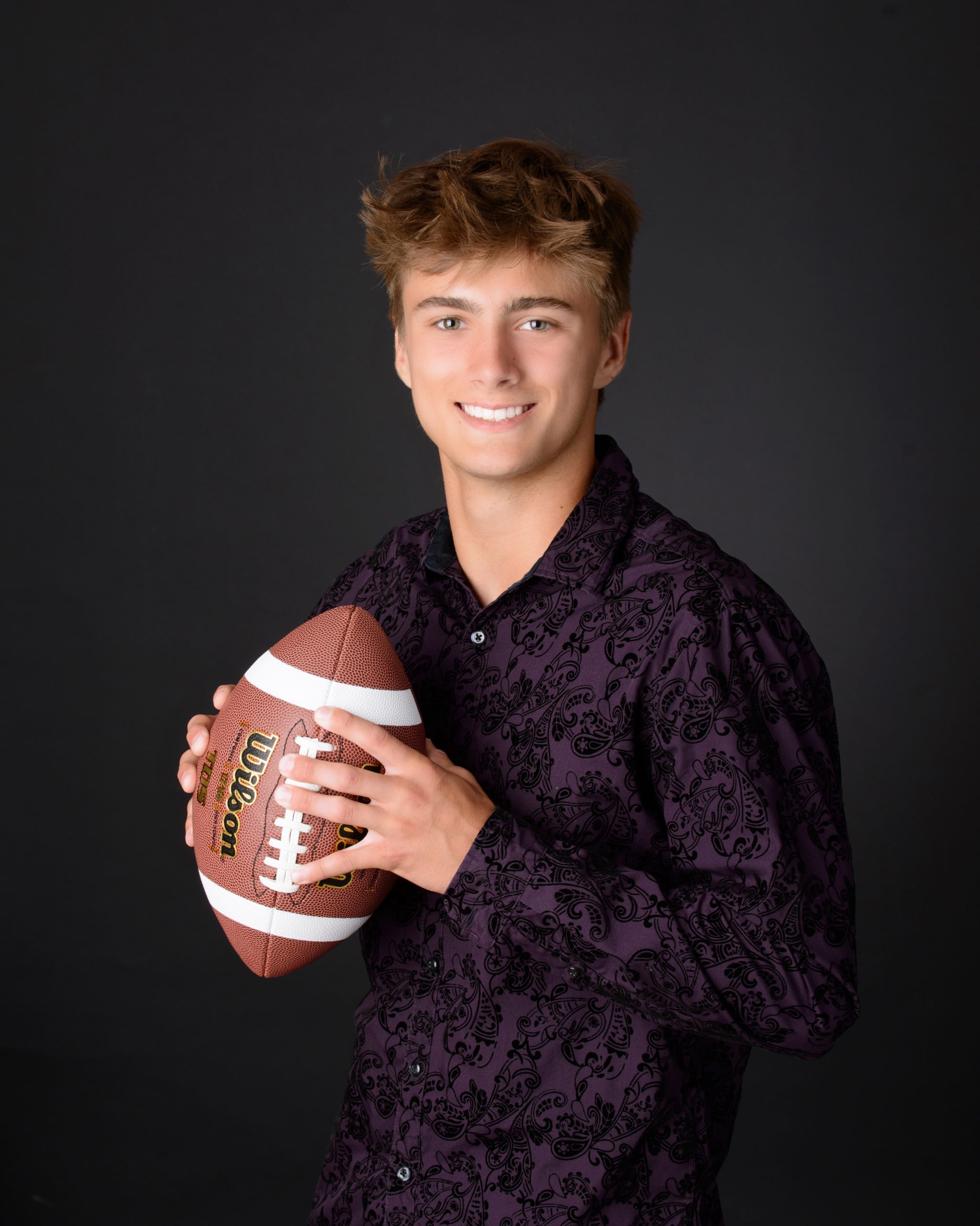 Casual Trenton senior session portrait showing a young man in layered clothing with a graffiti wall backdrop