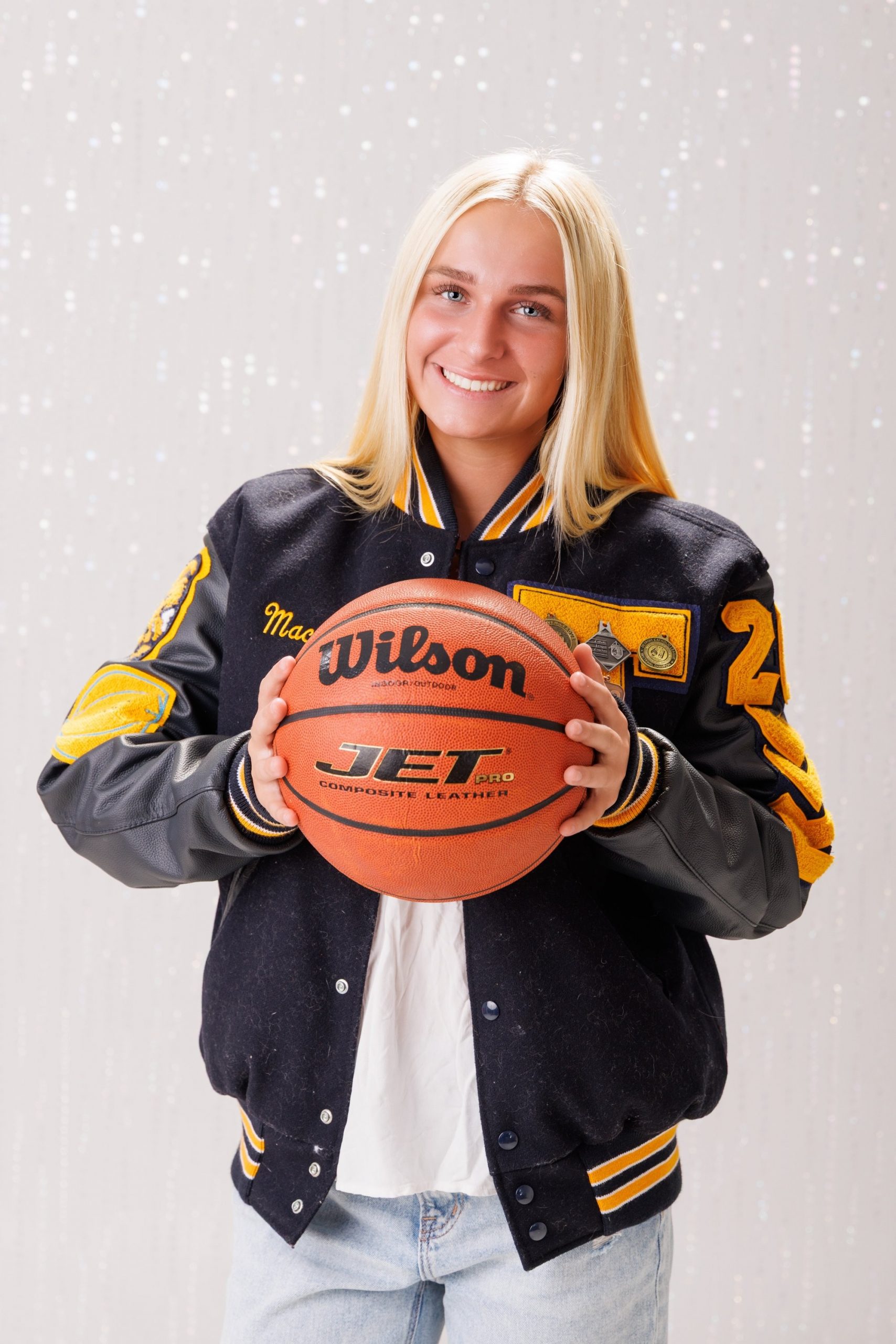 Back view of Alencia's Trenton Varsity jacket featuring 'Trenton' and 'Varsity' lettering with sports logos
