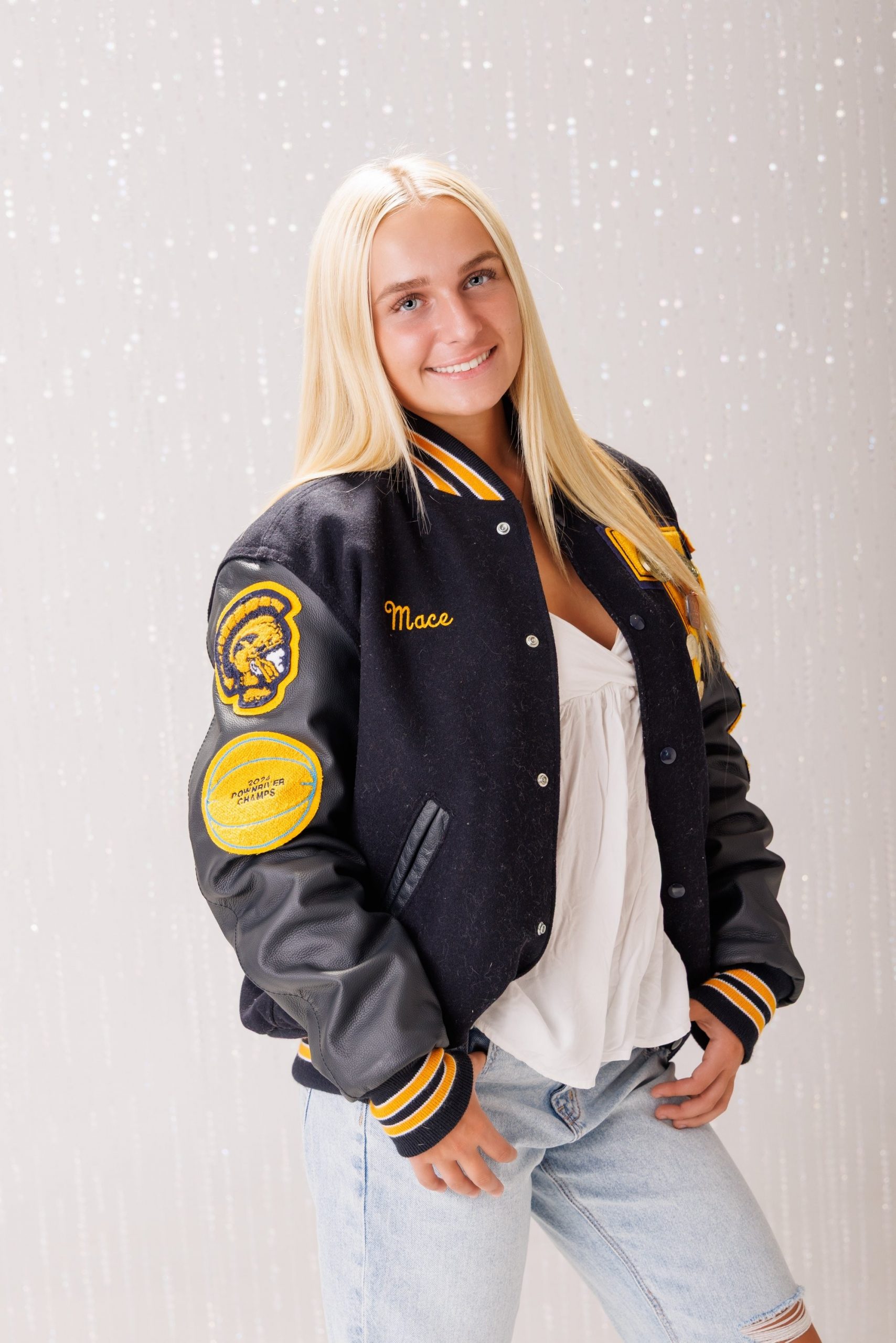 Back view of Alencia's Trenton Varsity jacket featuring 'Trenton' and 'Varsity' lettering with sports logos