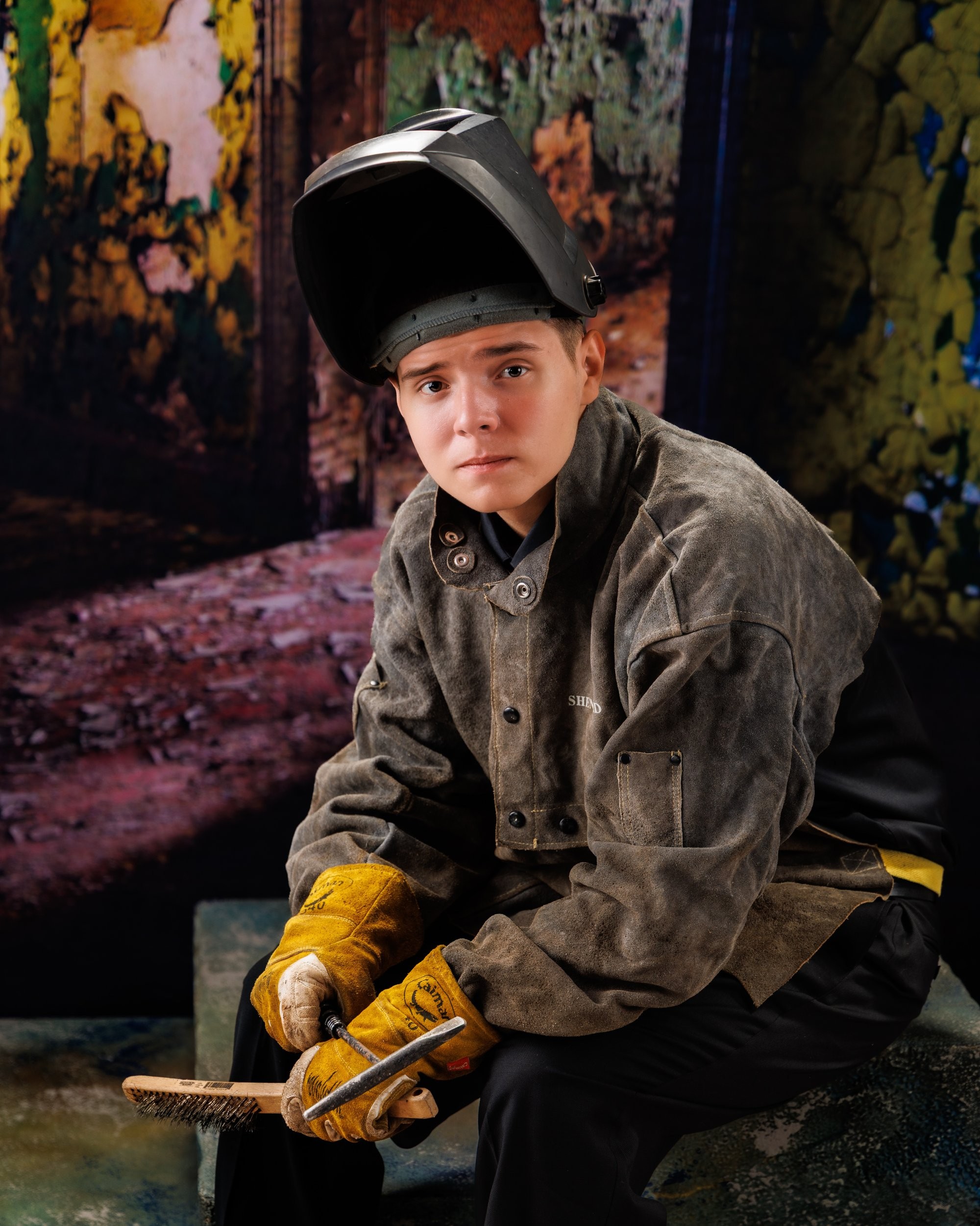 Creative Trenton senior portrait incorporating welding gear and industrial elements to highlight Downriver photography's artistic style