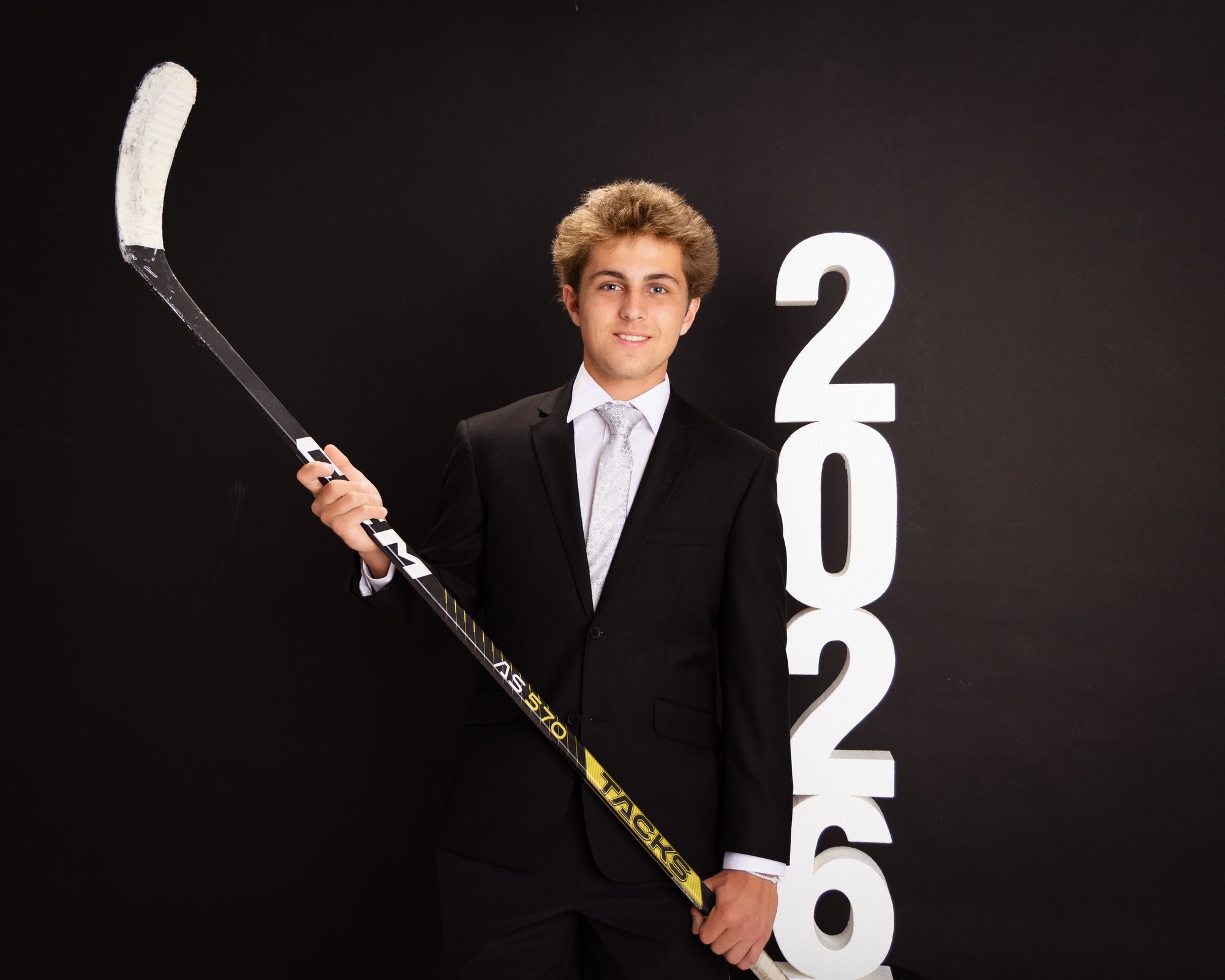 Senior photo of Zack with baseball bat and '2026' text in Trenton photo studio
