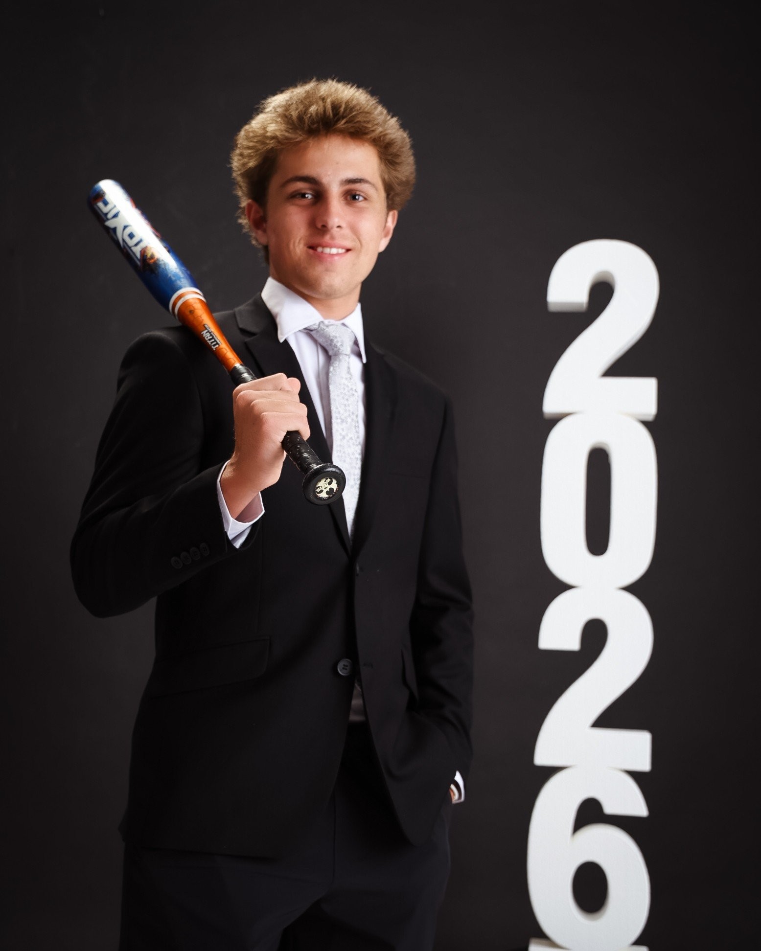 Senior photo of Zack with baseball bat and '2026' text in Trenton photo studio