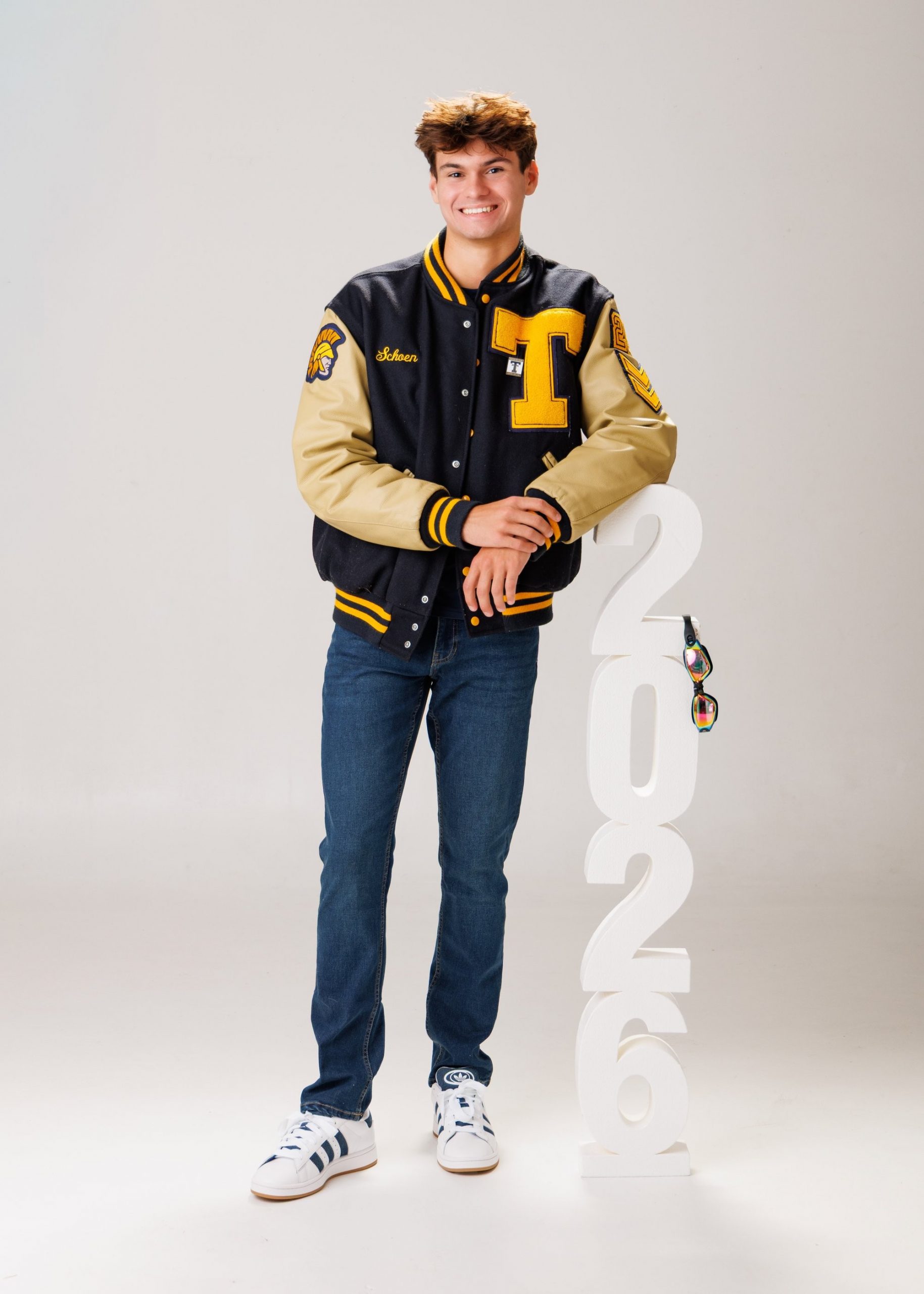 Zachary’s casual senior photo shoot with striped polo and vintage luggage in Trenton setting