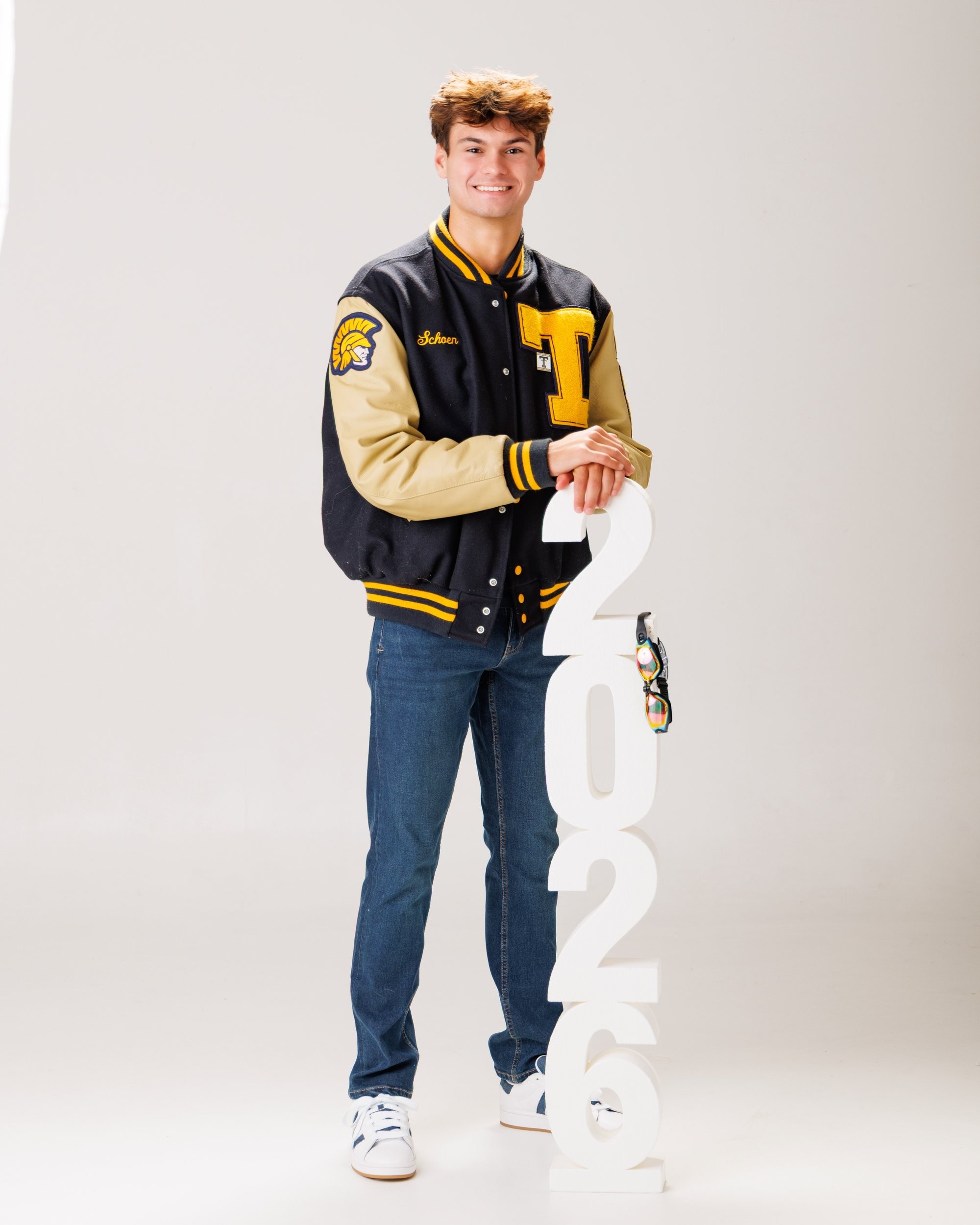 Zachary’s casual senior photo shoot with striped polo and vintage luggage in Trenton setting