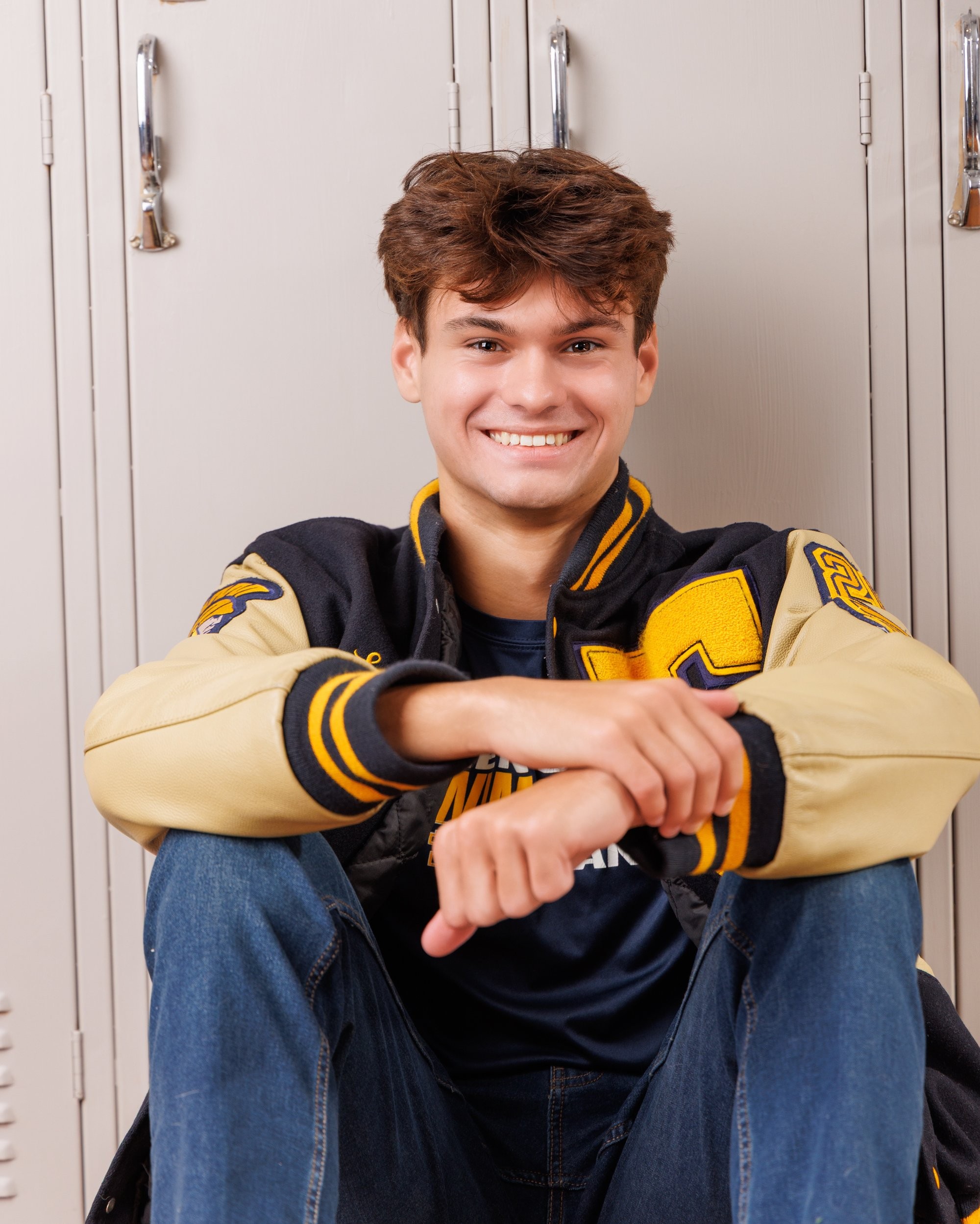 Zachary’s casual senior photo shoot with striped polo and vintage luggage in Trenton setting