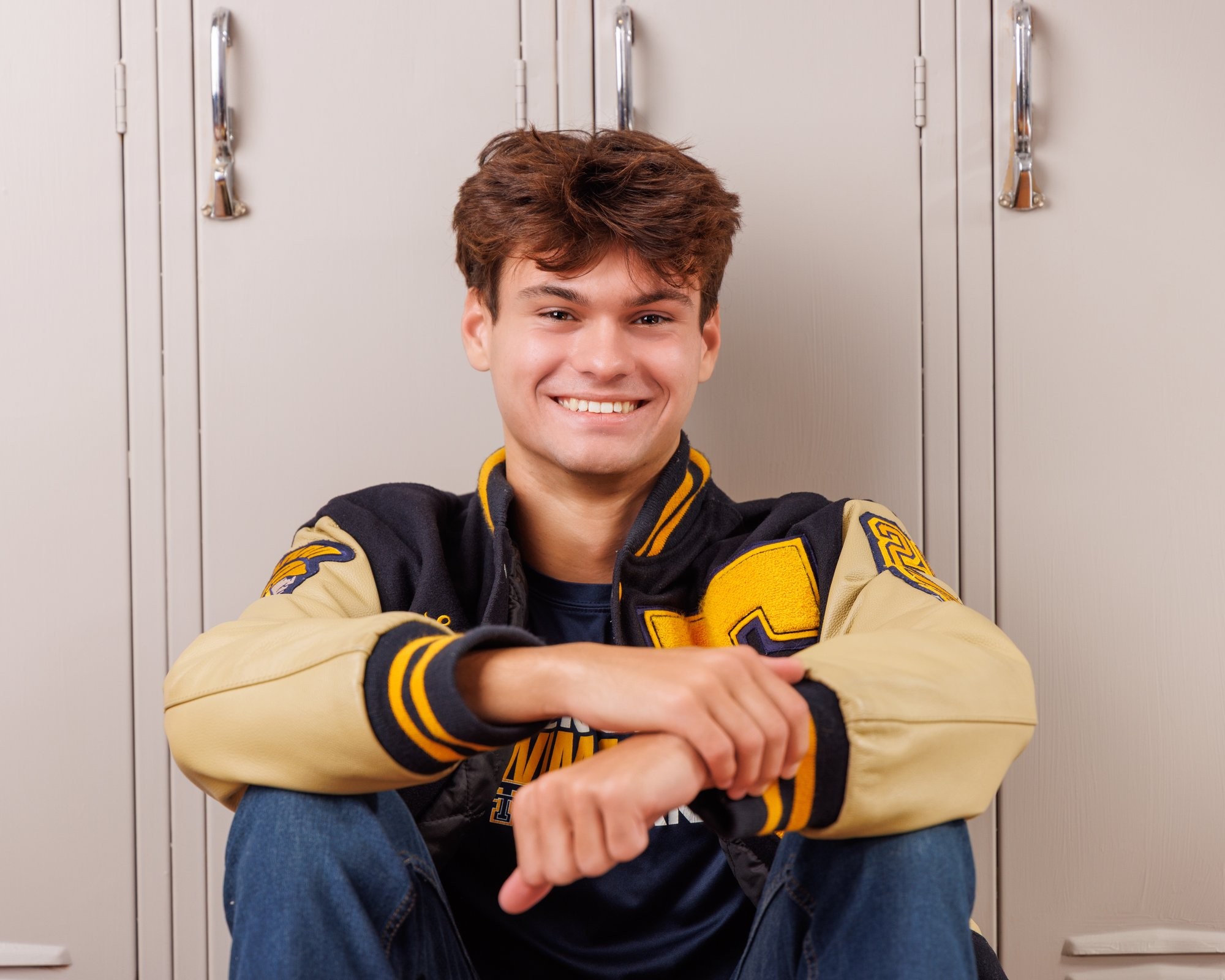 Zachary’s casual senior photo shoot with striped polo and vintage luggage in Trenton setting