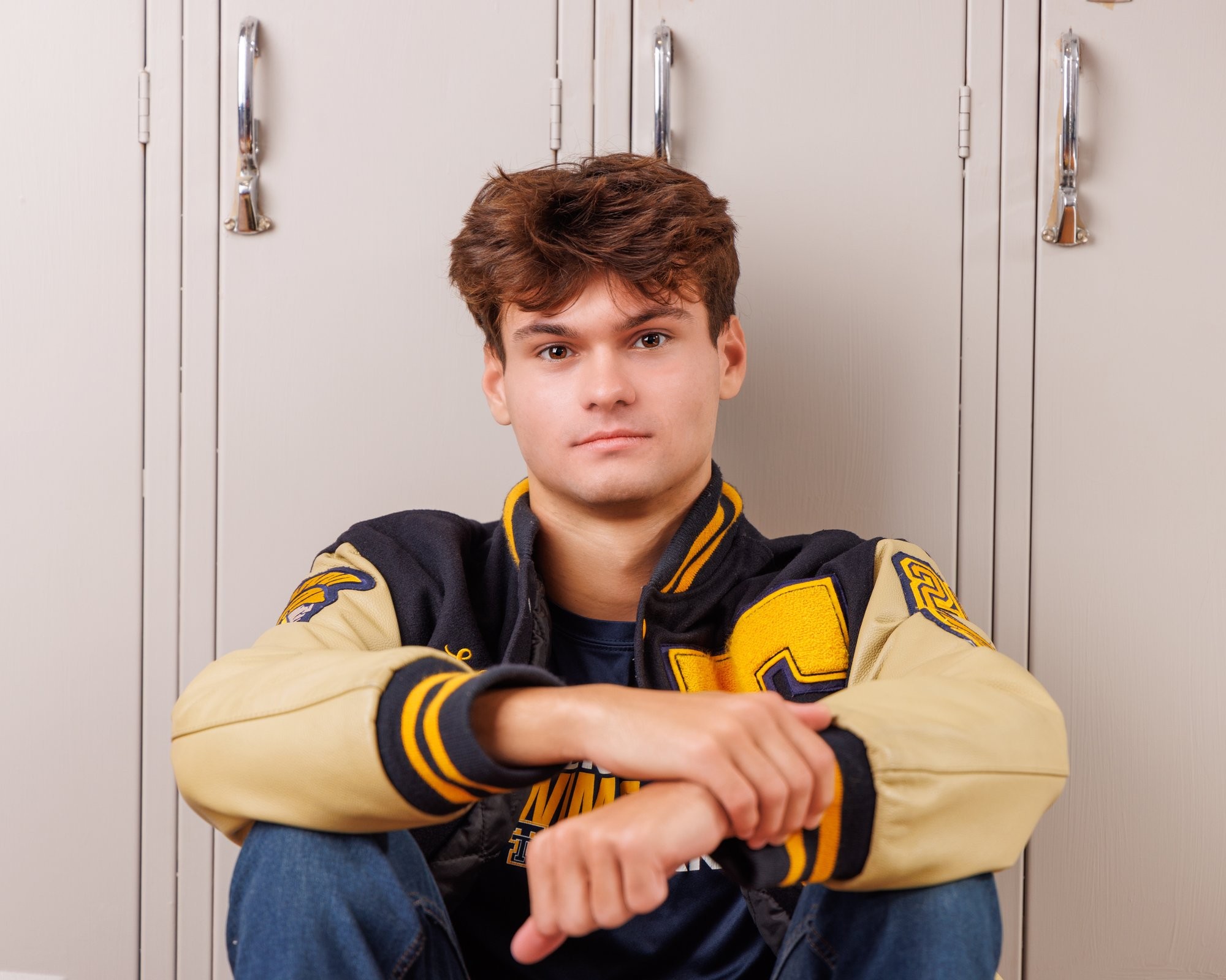 Zachary’s casual senior photo shoot with striped polo and vintage luggage in Trenton setting