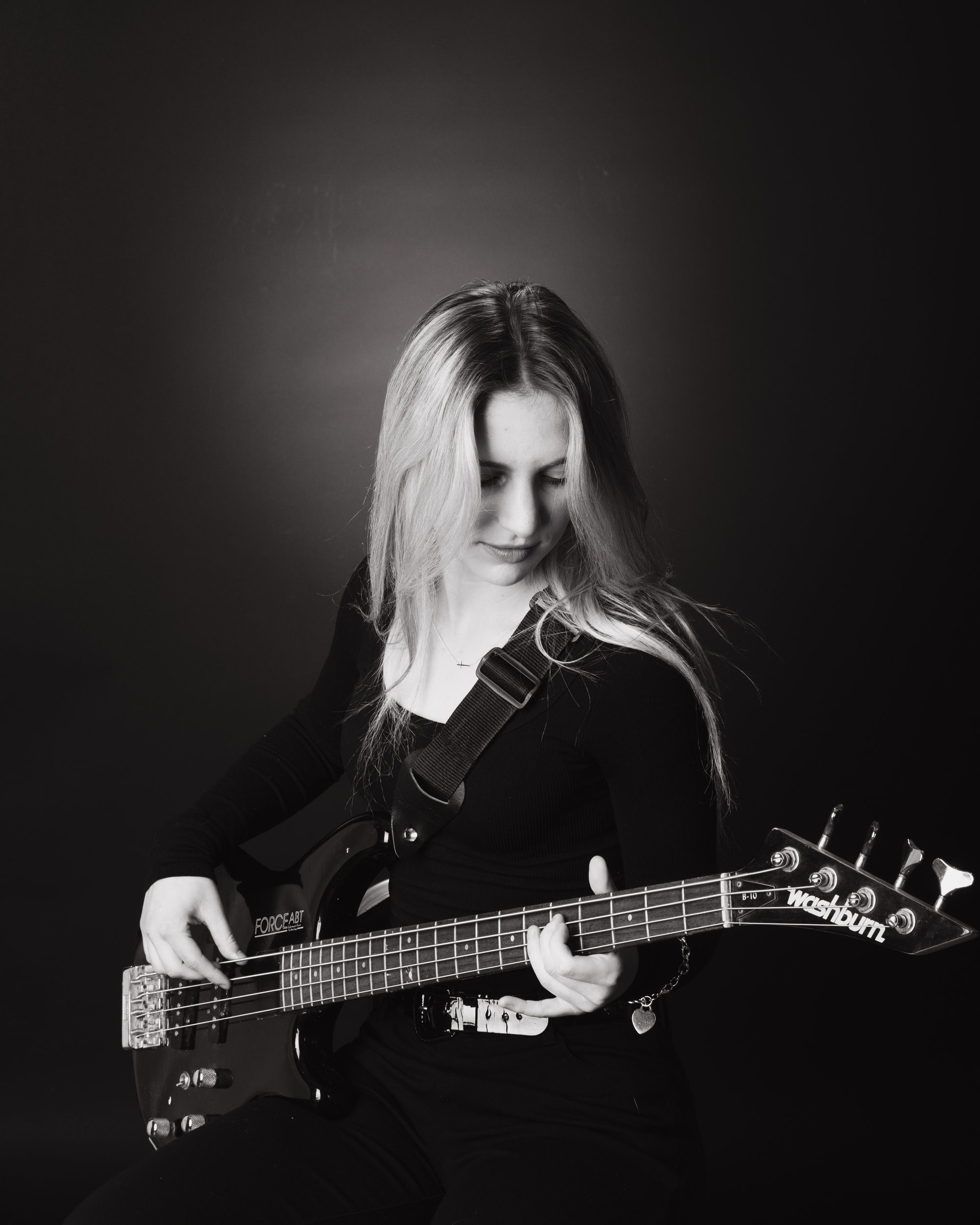 Senior portrait of Tegan holding a bass guitar, captured by a Trenton photo studio