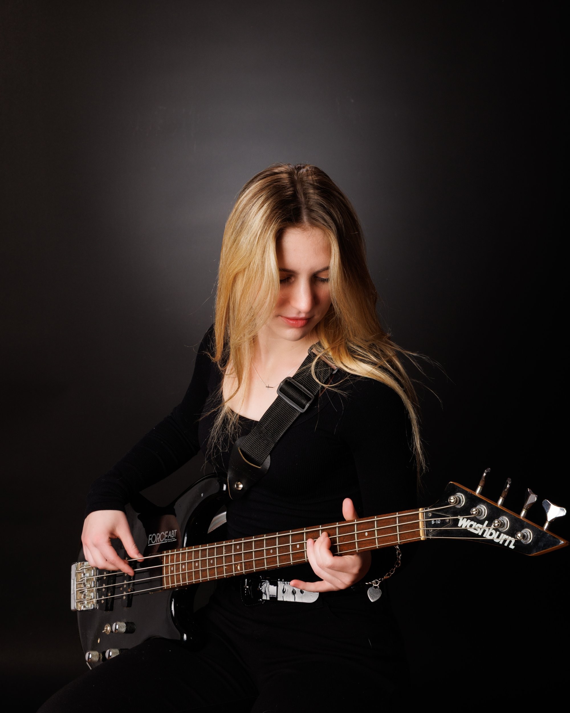 Senior portrait of Tegan holding a bass guitar, captured by a Trenton photo studio