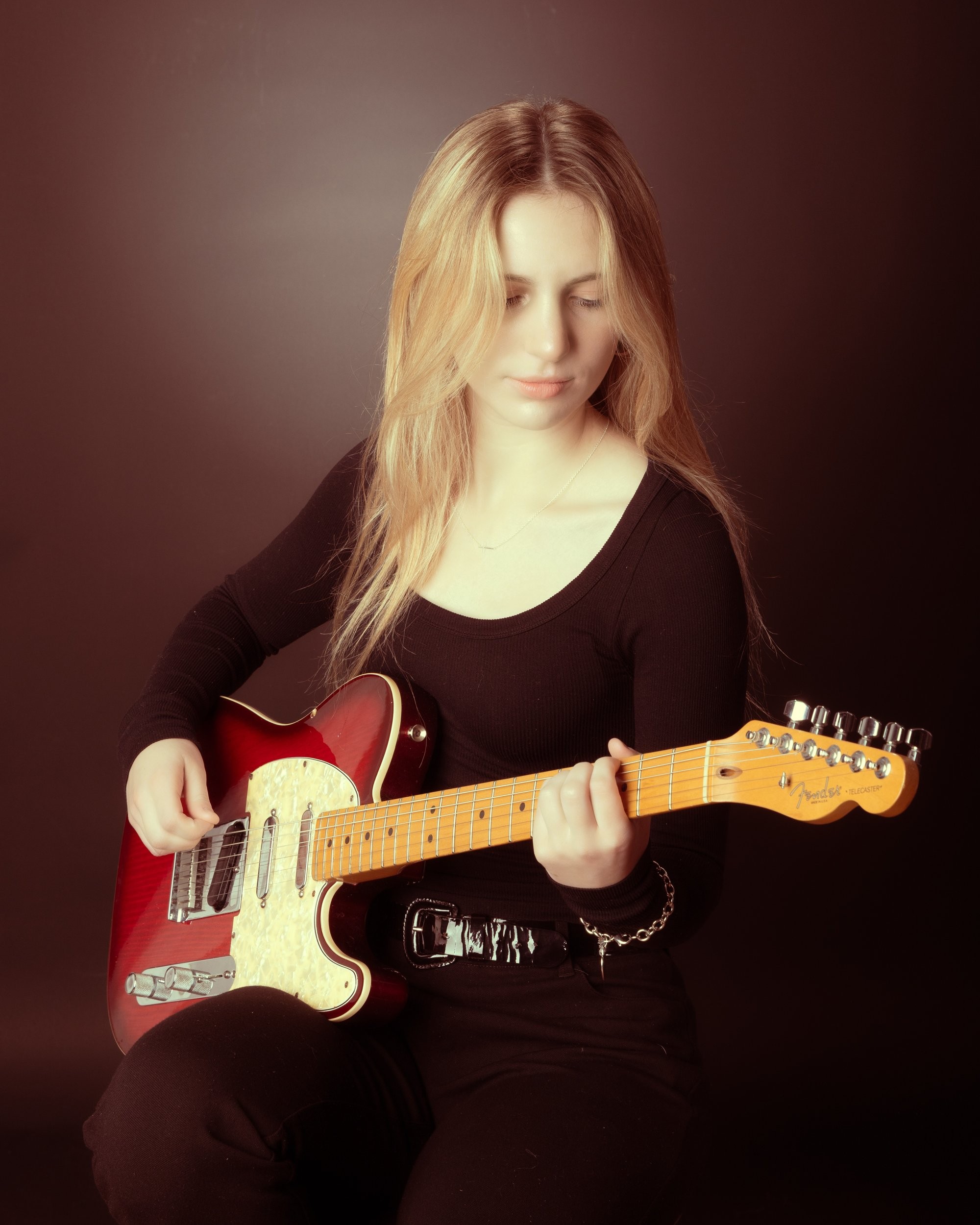Senior portrait of Tegan holding a bass guitar, captured by a Trenton photo studio