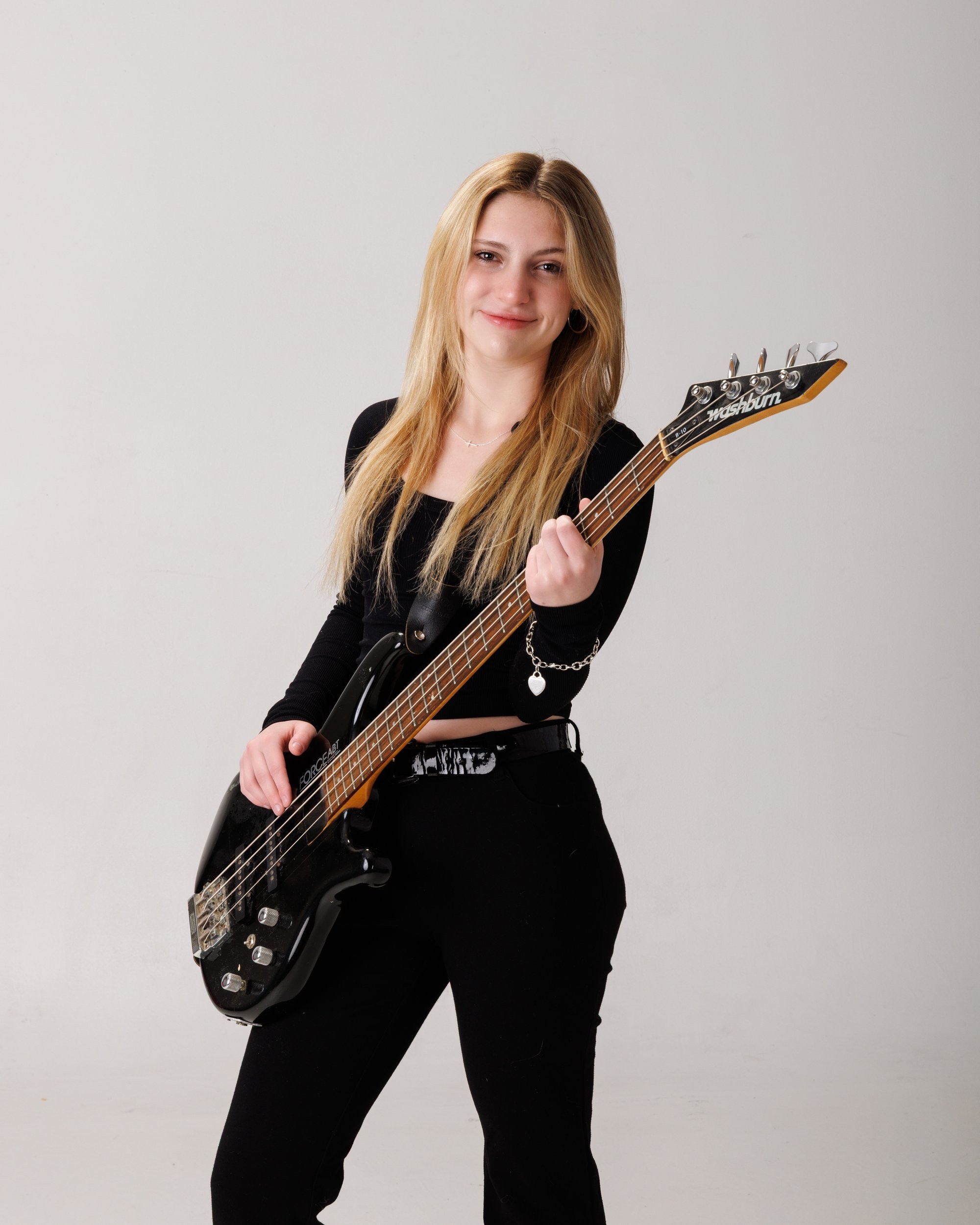 Senior portrait of Tegan holding a bass guitar, captured by a Trenton photo studio