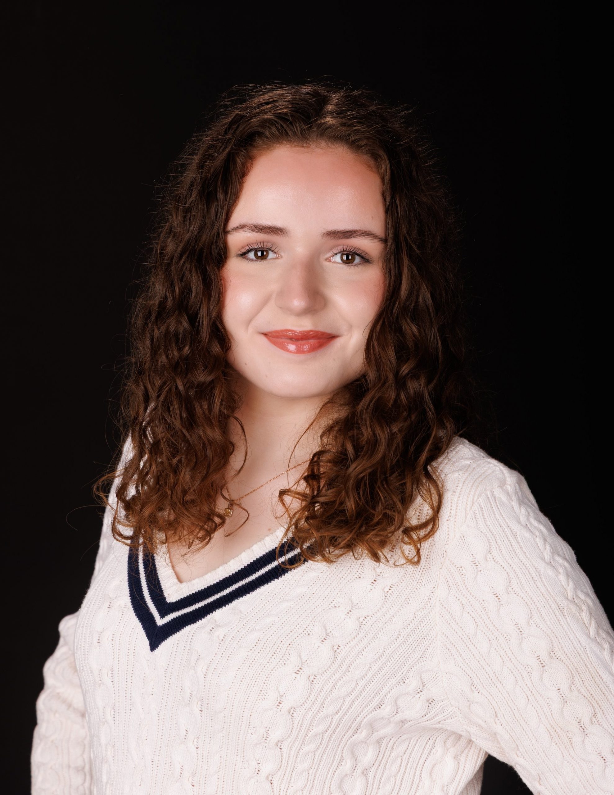 Viona's vibrant background senior portrait with confident expression and school-themed elements