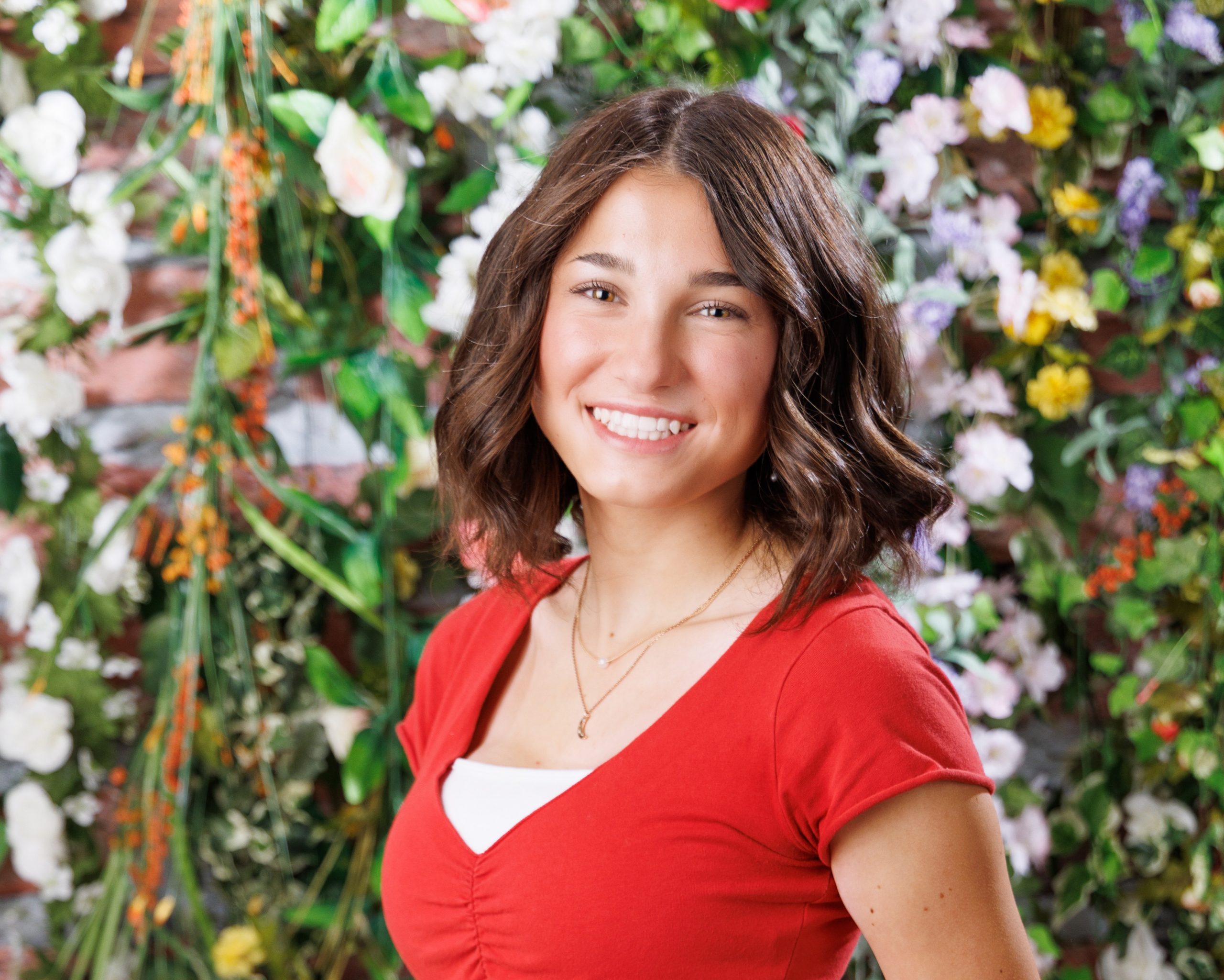 Anna in gray dress leaning against white wall for Woodhaven Senior Portraits