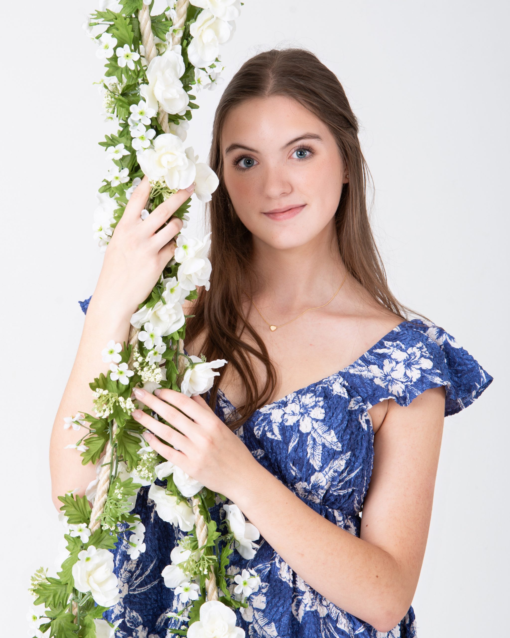 Senior woman holding floral swing in blue floral dress during Downriver photo session