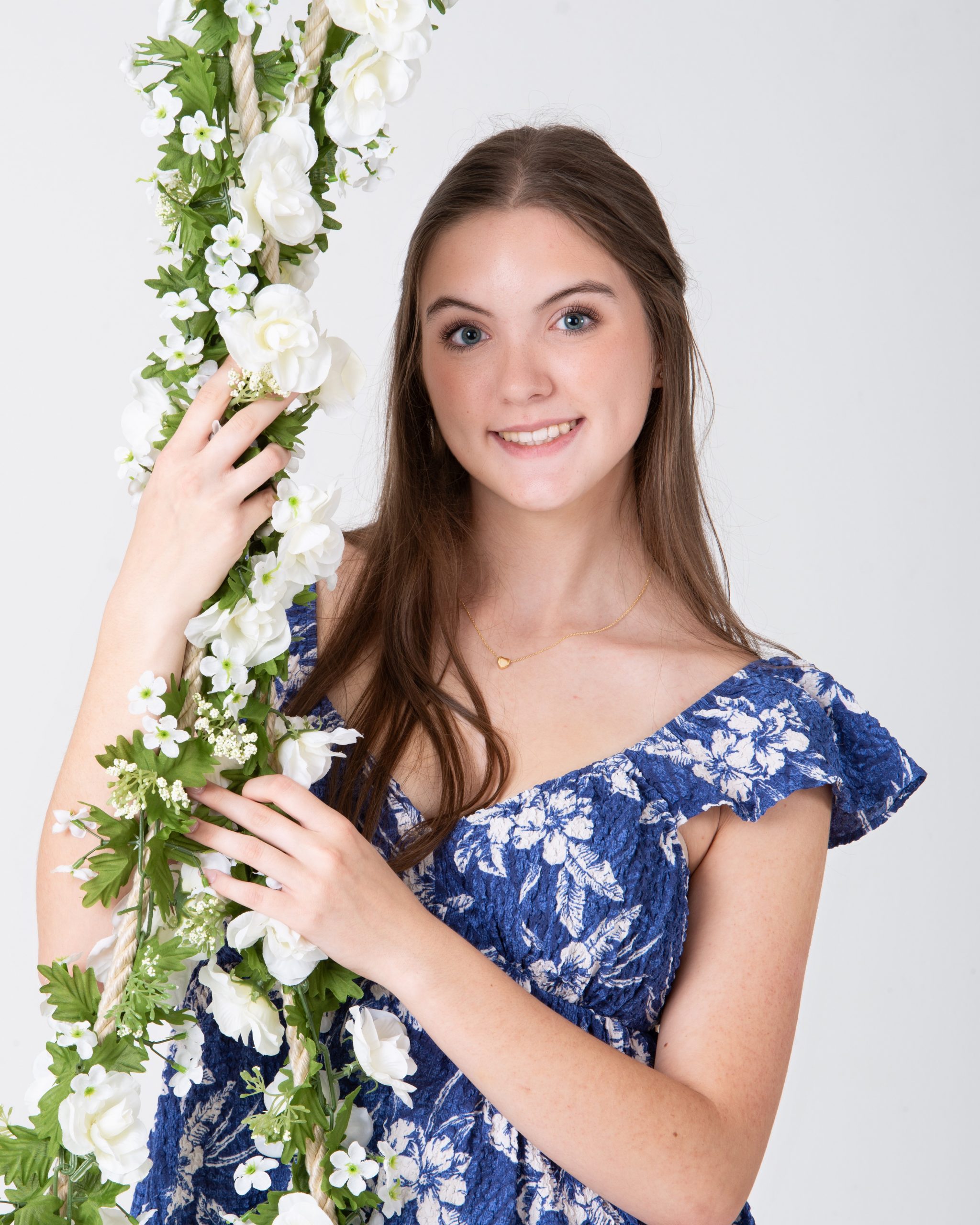 Senior woman holding floral swing in blue floral dress during Downriver photo session