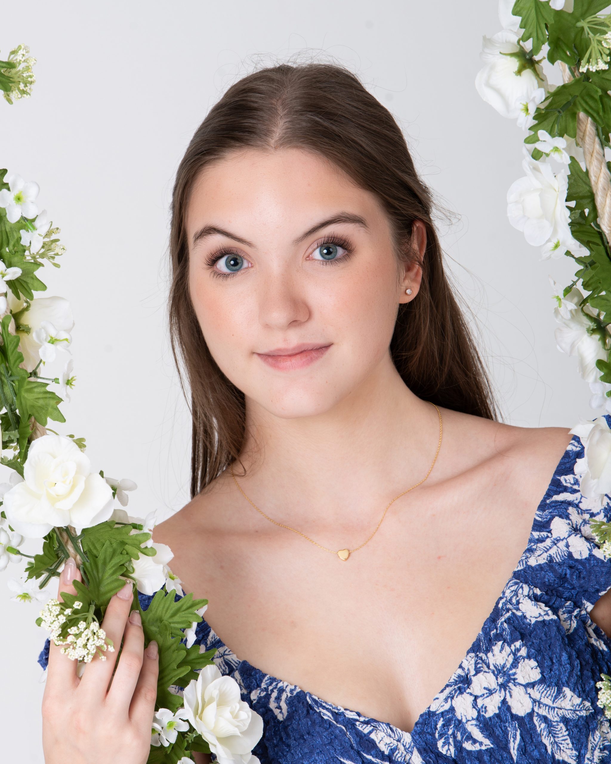 Senior woman holding floral swing in blue floral dress during Downriver photo session