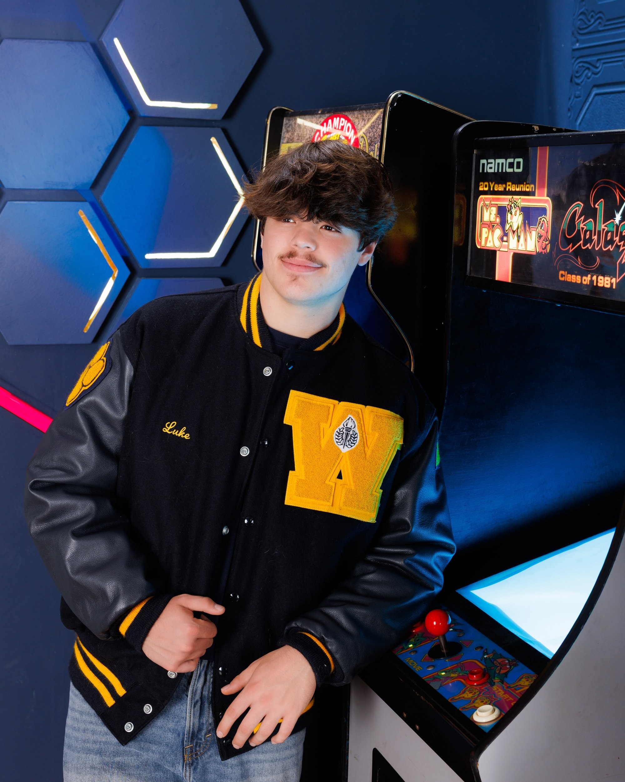 Luke in blue graduation gown and cap with 'Class of 2026' chalkboard, Downriver photo studio